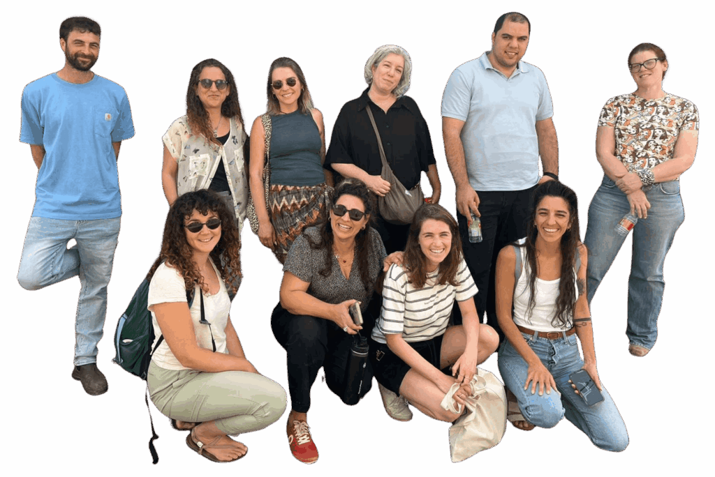 קבוצת אנשים מחייכים במגוון בגדים צבעוניים, עומדים ויושבים יחד.